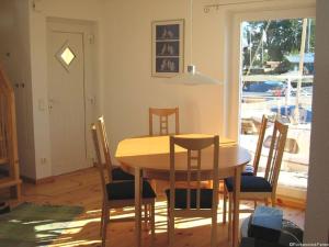 een eetkamer met een houten tafel en stoelen bij FLOATING HOUSES Comfort - "Schwimmende Ferienhäuser" - Haus 7 in Kröslin +16 foto's