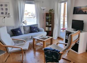 a living room with a couch and chairs and a tv at FLOATING HOUSES - "schwimmende Ferienhäuser" - Haus 3 in Kröslin