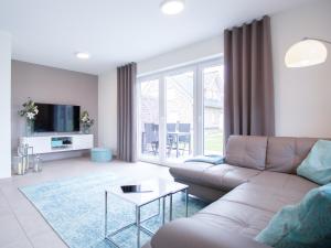 a living room with a couch and a table at Ferienhaus JONA in Burhave +8 photos