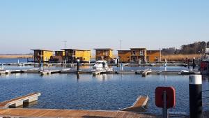 a marina with houses and a boat in the water at FLOATING HOUSES - "schwimmende Ferienhäuser" - Haus 1 in Kröslin