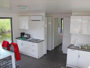 eine weiße Küche mit weißen Schränken und einem Fenster in der Unterkunft Hausboot - FLOATING 44 in Ueckermünde in Ueckermünde