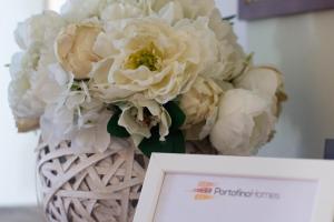 a bouquet of white flowers in a basket next to a sign at Daisy by PortofinoHomes in Santa Margherita Ligure