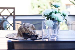 a table with a hat and sunglasses and a vase of flowers at Daisy by PortofinoHomes in Santa Margherita Ligure