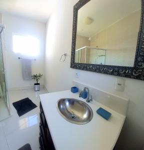 uma casa de banho com um lavatório e um espelho em Pousada Flor de Lis Homestay em Volta Redonda