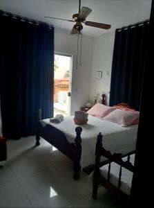 1 dormitorio con 1 cama con cortinas azules y ventana en Pousada Flor de Lis Homestay, en Volta Redonda