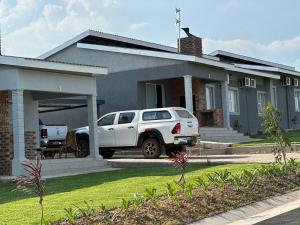 un camión blanco estacionado frente a una casa en Canal View Estate & Resort, en Manzini