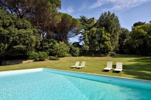 una piscina con 2 tumbonas y un patio en Torre delle Cornacchie, en Roma