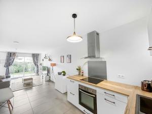 a kitchen with white cabinets and a stove top oven at L'Eclat de la Gironde in La Hourcade