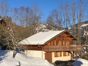 a log cabin with snow on the roof at Chalet Chocolat Chatel in Châtel