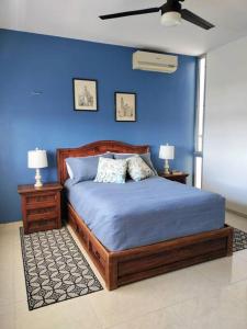 um quarto com uma parede azul, uma cama e 2 candeeiros. em Casa Laák´Fabulous rustic townhouse with pool em Mérida