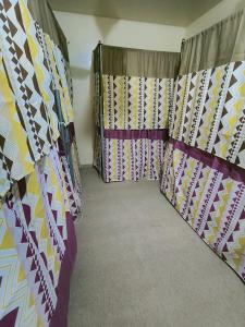 ドバイにあるorange hostelのカーテン付きのベッドが備わる客室です。