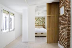 una camera con letto e muro di mattoni di apartamento el barrio de lavapies a Madrid