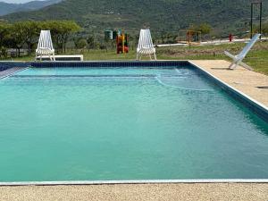 una piscina con 2 sillas y un parque infantil en Canal View Estate & Resort, en Manzini