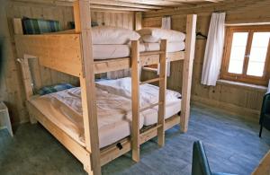 two bunk beds in a wooden room with a window at Gruppen- & Familienhaus Parsonz in Reams