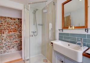 a bathroom with a sink and a shower at Miller's Cottage, The Old Mill in Snape