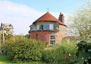 an old brick house with a window on top of it at Miller's Cottage, The Old Mill in Snape