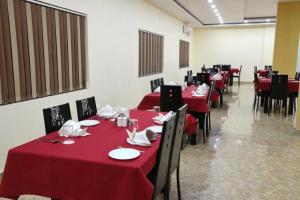 a dining room with red tables and chairs with red table cloth at HOTEL MARIYA INTERNATIONAL in Bodh Gaya