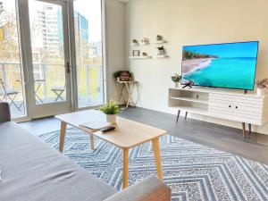 een woonkamer met een tv en een bank bij Stunning Apartment By Petco Park! in San Diego