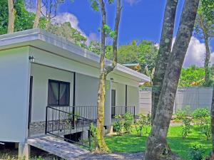 una pequeña casa blanca en medio de los árboles en Monteverde Magic Mountain, en Monteverde