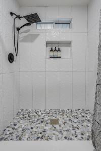 a bathroom with a shower with a tile floor at Avocado Bliss Retreat in Valley Center