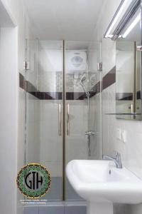 a white bathroom with a sink and a shower at Gullivers Travel Hotel in Apenkwa
