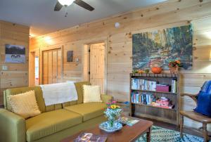 een woonkamer met een bank en een boekenplank bij Baby Bear: Peaceful cabin on Bearwallow Mountain with hot tub and close to hiking! in Hendersonville