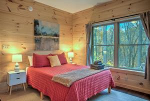 een slaapkamer met een bed en een groot raam bij Baby Bear: Peaceful cabin on Bearwallow Mountain with hot tub and close to hiking! in Hendersonville