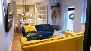 a living room with a yellow couch and a kitchen at City Studio Kormoran in Bremerhaven