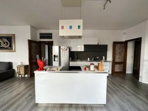 una cucina con isola bianca in una camera di Diego's House ad Aci Castello