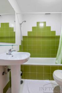 a green bathroom with a sink and a tub at Inftour Medici Apartamento in Calpe