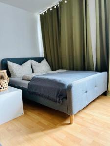 a blue bed in a room with a curtain at Mülheim an der Ruhr innenstadt in Mülheim an der Ruhr