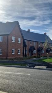 a large red brick building with black roofs at Modern 2bedroom House in Ipswich Suffolk in Ipswich