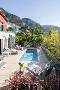 uma piscina num deque com cadeiras e árvores em GROUND FLOOR VILLA GRAZIELLA 200 M FROM THE BEACH em Èze