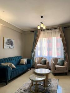 sala de estar con sofá azul y mesa en Cozy apartment in heart of Kampala en Kira
