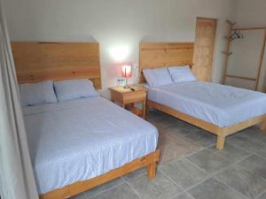 a bedroom with two beds and a table with a lamp at Bungalow Vista Sierra Laguna in San Carlos