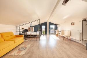 a living room with a yellow couch and a dining room at Hostel StepIn in Kutaisi