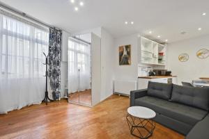 a living room with a couch and a table at The Mews Apartment In Kensington in London