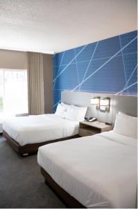 een hotelkamer met 2 bedden en een blauwe muur bij Comfort Inn Sioux City South in Morningside