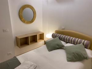 een slaapkamer met een bed met 2 kussens en een spiegel bij Clara's Home in Rome