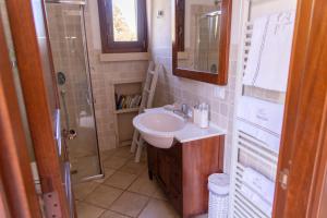 uma casa de banho com um lavatório e um chuveiro em Masseria Caliani em Borgagne