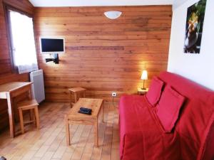 a living room with a red couch and a table at Les aubépines in Brocas