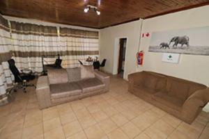 a living room with two brown couches in a room at Quintax Guest House in Pretoria