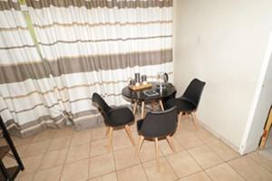 a dining room with a table and black chairs at Quintax Guest House in Pretoria