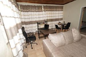 a living room with a couch and a table with chairs at Quintax Guest House in Pretoria