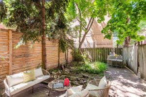 a patio with a couch and chairs in front of a fence at Sweet Home in Toronto