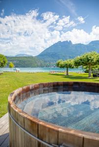 a hot tub with a view of a lake and mountains at Le Clos Marcel in Duingt