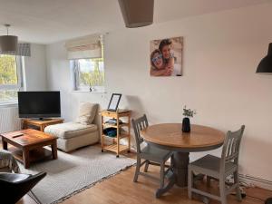 a living room with a table and a couch at Cosy flat in the Heart of Wandsworth in London