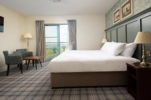a hotel room with a bed and a desk and chair at The Tynemouth Castle Inn - The Inn Collection Group in Tynemouth