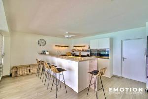 a kitchen with a counter and stools in a room at Appartement 2 chambres sur la plage de grand case in Grand Case