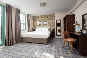 a bedroom with a bed and a desk and a chair at The Tynemouth Castle Inn - The Inn Collection Group in Tynemouth